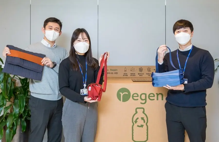  * 효성티앤씨 직원들이 사내 페트병 수거함 앞에서 친환경 섬유 리젠으로 만든 가방을 선보이고 있다