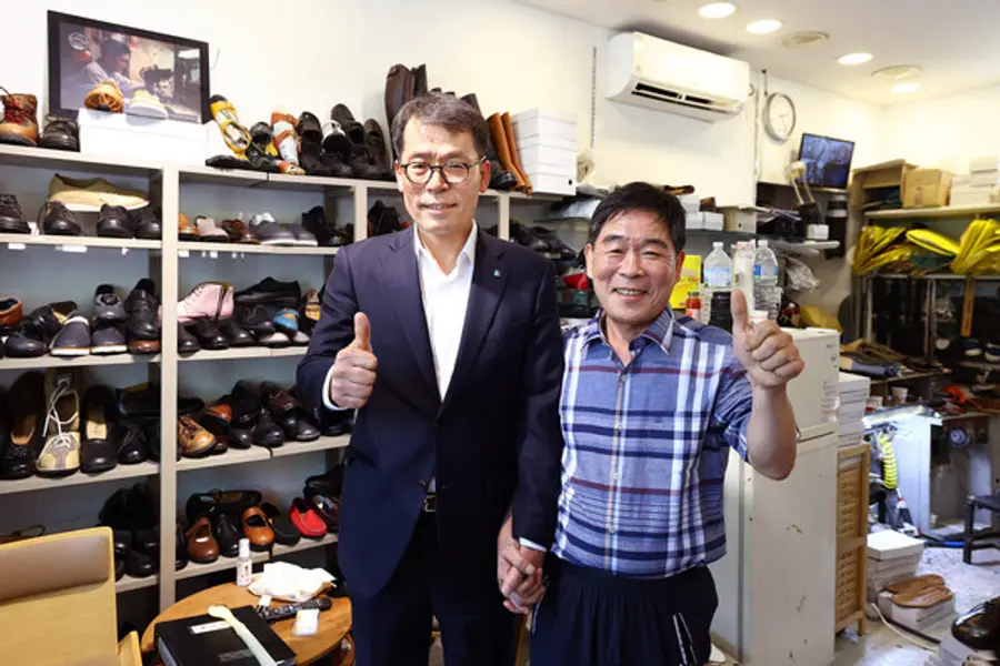 김성태 IBK기업은행장(왼쪽)이 4일 서울 염천교 수제화거리를 찾아 고기황 이태리제화 대표(오른쪽)의 점포에서 수제화를 구입했다. [출처: IBK기업은행]
