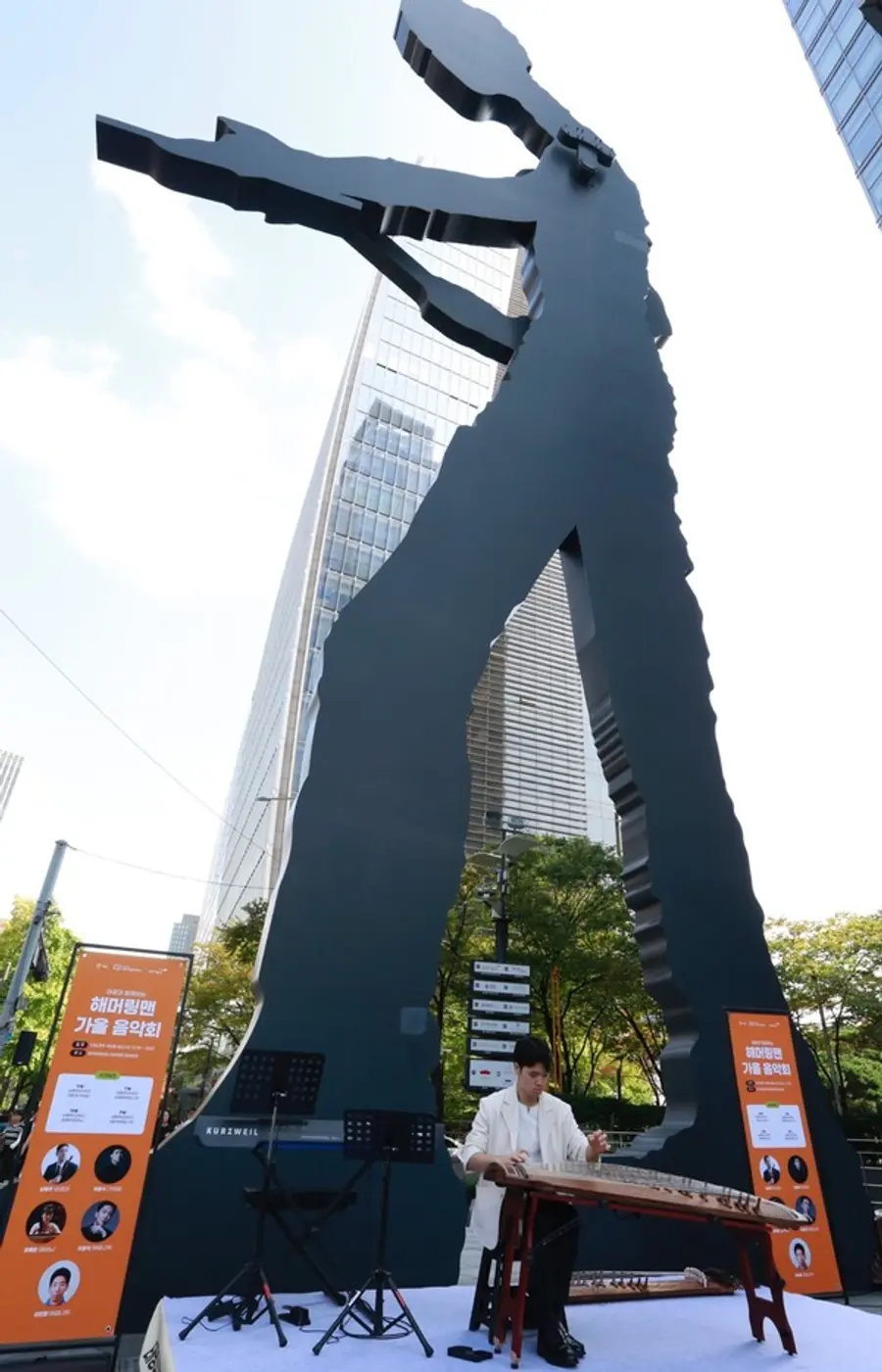 일주학술문화재단 장학생 출신이자 가야금 연주자 어윤석이 광화문 랜드마크 ‘해머링맨’ 앞에 마련된 야외무대에서 연주하고 있다. (사진제공=태광그룹)