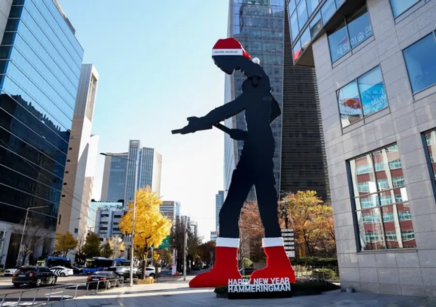 서울 광화문의 랜드마크 '해머링맨'이 산타 모자를 쓰고 빨간 양말을 신은 모습으로 25일 시민들에게 공개됐다. (사진제공=태광그룹)