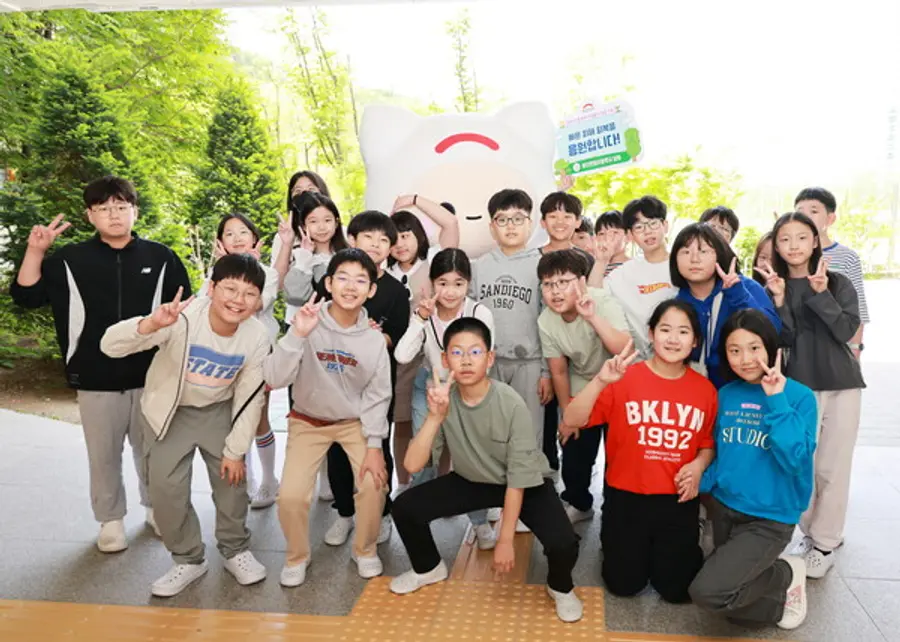 산불 피해 이웃을 위한 성금 모금에 참여한 용인한얼초등학교 학생들이 희망브리지 캐릭터 ‘희망이’와 기념사진을 촬영하고 있다. (사진=희망브리지)