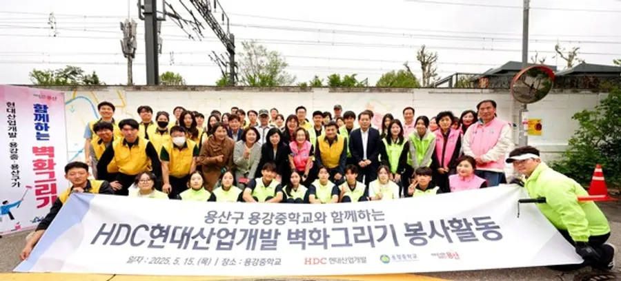 HDC현대산업개발 도시정비부문 임직원과 용산구 주민, 용강중학교 학생 등 40여 명과 함께 서울시 용산구 용강중학교 일대 담장 벽화그리기 봉사활동을 진행했다.(사진=HDC현대산업개발)