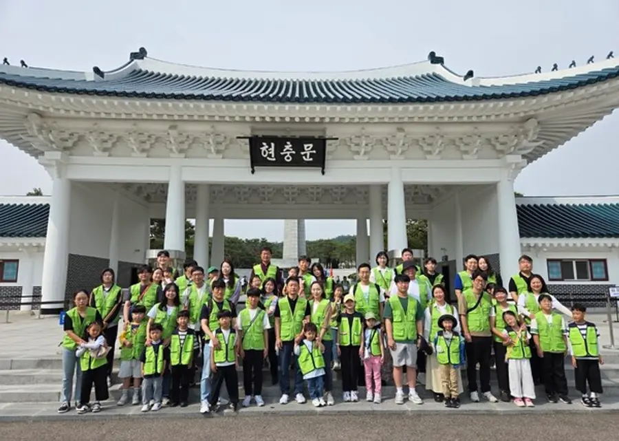 현대엔지니어링 임직원 및 임직원 가족이 국립서울현충원에서 묘역 정화 봉사활동을 한 뒤, 기념촬영을 하고 있다. (사진제공=현대엔지니어링)