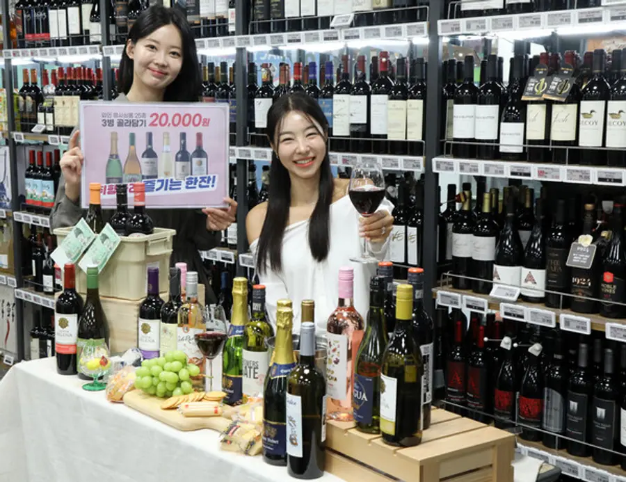 이마트 용산점에서 모델들이 17일(목)부터 31일(목)까지 업계 최초로 선보이는 '와인 골라담기' 행사를 소개하고 있다. (사진제공=이마트)