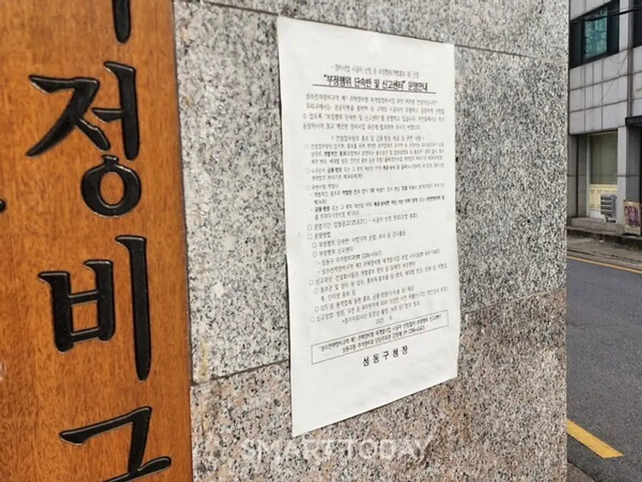 성수1지구 조합 사무실 1층 외벽에 붙여진 성동구청의 '부정행위 단속반 및 신고센터 운영' 공문. 출처=김종현 기자