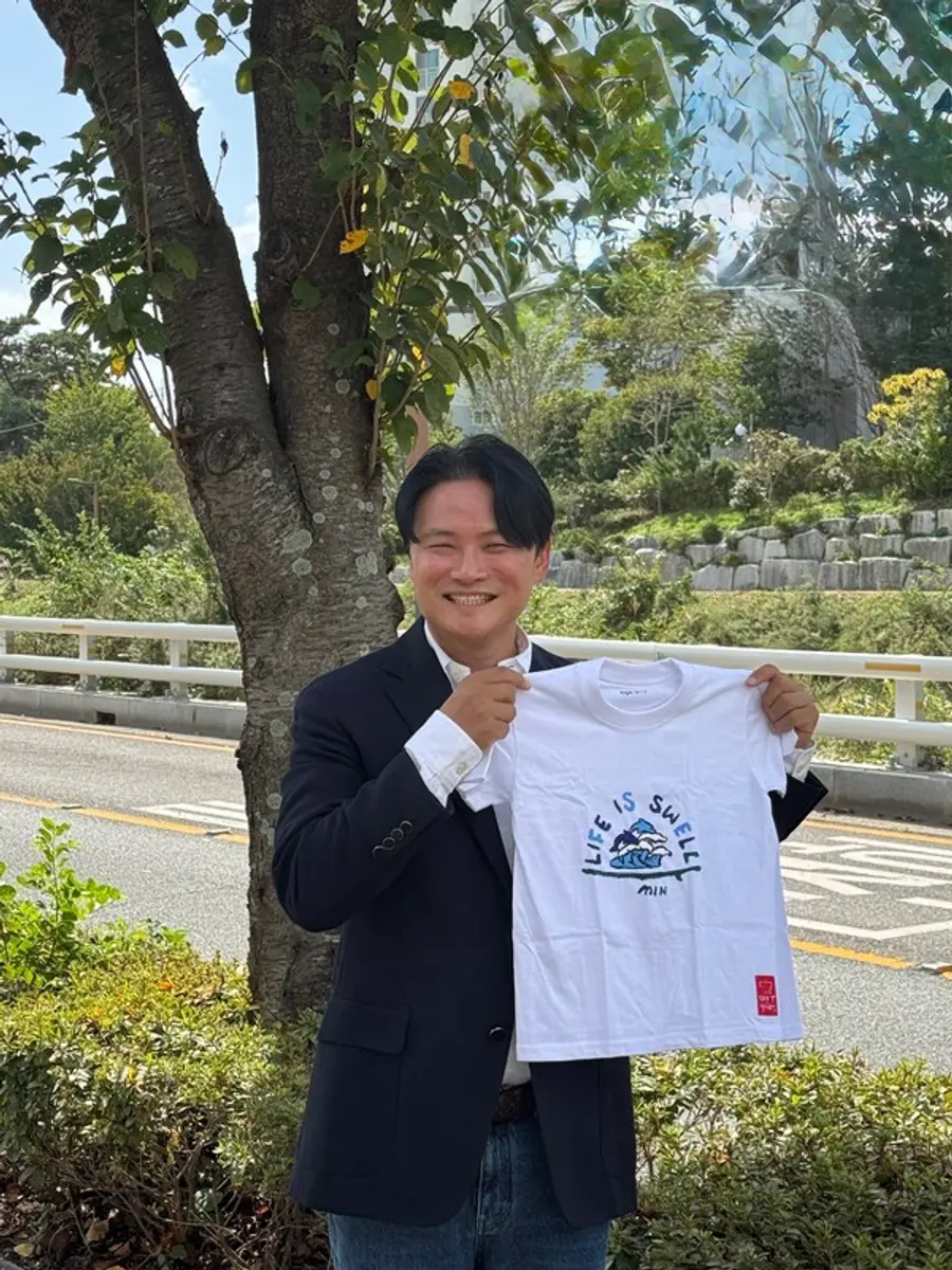 희망T 캠페인의 캠페이너로 참여하는 송민 대한민국 서핑 국가대표 감독이 직접 그린 희망T를 들고 사진촬영을 하고 있다.(사진제공=희망브리지)