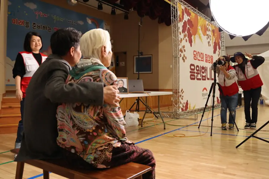 전국재해구호협회 자원봉사자가 어르신의 장수사진을 촬영하고 있다(사진제공=희망브리지)