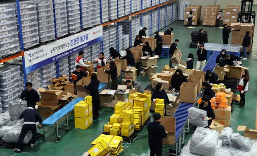  JB우리캐피탈 임직원 37명이 지난달 29일 경기도 파주 희망브리지 재해구호물류센터에서 방한키트 500세트를 제작하고 있다(사진제공=희망브리지)