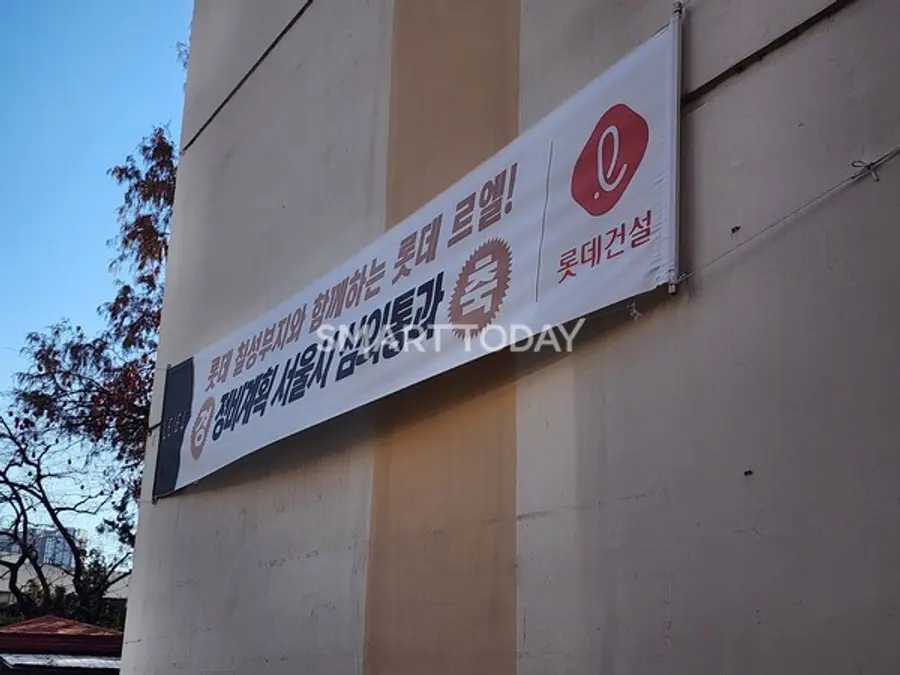 서초 진흥아파트 외벽에 걸린 롯데건설 홍보 플랜카드. 롯데칠성 부지 개발과 연계해 사업을 추진한다는 문구가 적혀 있다. 출처=김종현 기자
