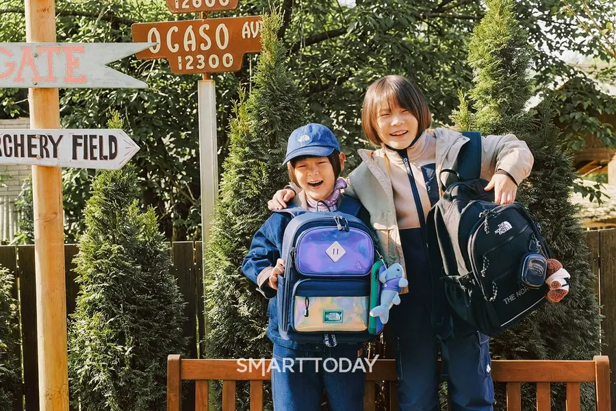 '2026 노스페이스 신학기 키즈 가방’을 든 홍보대사 신우 · 이준(좌) (사진=영원아웃도어)
