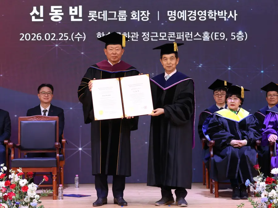 25일 대전 카이스트(KAIST) 본원에서 열린 2026년도 명예박사 학위수여식에서 신동빈 롯데 회장(왼쪽)이 이광형 총장으로부터 명예경영학 박사 학위를 받고 있다. 롯데 제공