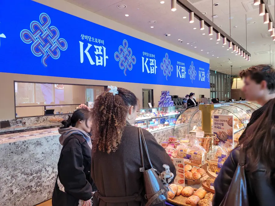 19일 서울 종로구에 위치한 파리바게뜨 광화문 1945점을 찾은 외국인들이 ‘K파바’ 비전이 적용된 특화 제품를 구경하고 있다. (사진=파리바게뜨)