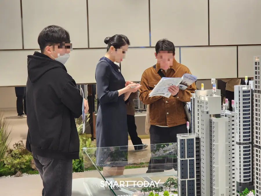 참관객과 안내원이 더샵 신길센트럴시티 모형도를 보며 얘기를 나누고 있다. 출처=김종현 기자