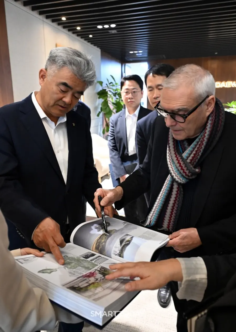 도미니크 페로(오른쪽)가 본인의 작품집 중 여수 장도 설계에 대해 대우건설 정원주 회장에게 설명하고 있다. (사진제공=대우건설)