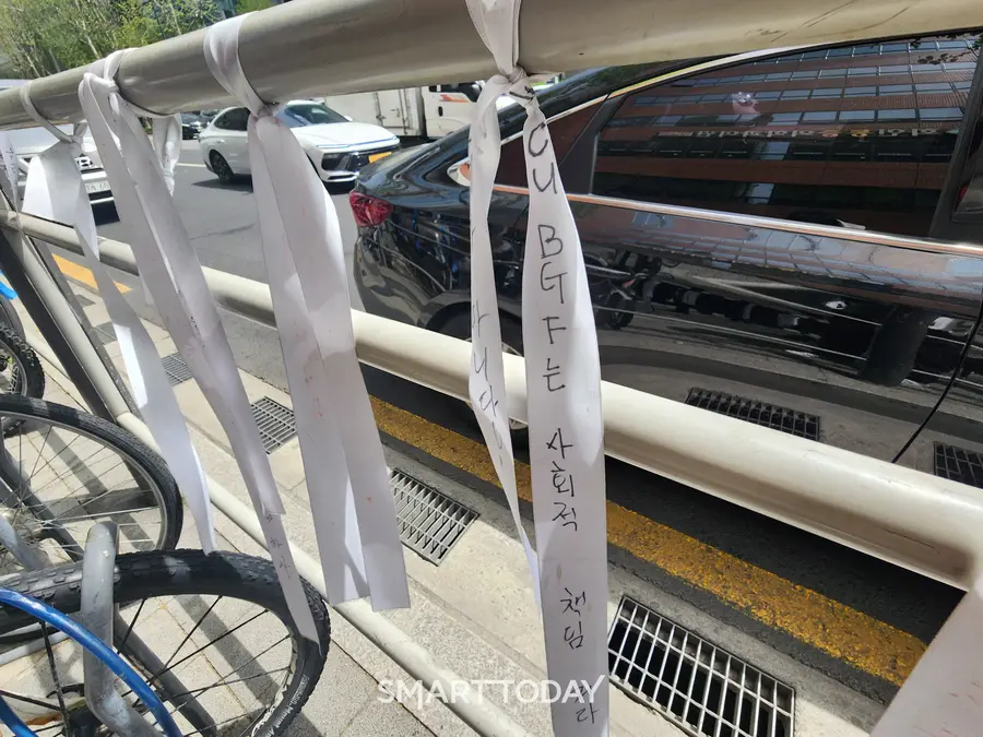 BGF리테일 CU 사옥 앞 도로 난간에 '사회적 책임 다하라'는 리본이 묶여져 있다. 출처=김종현 기자