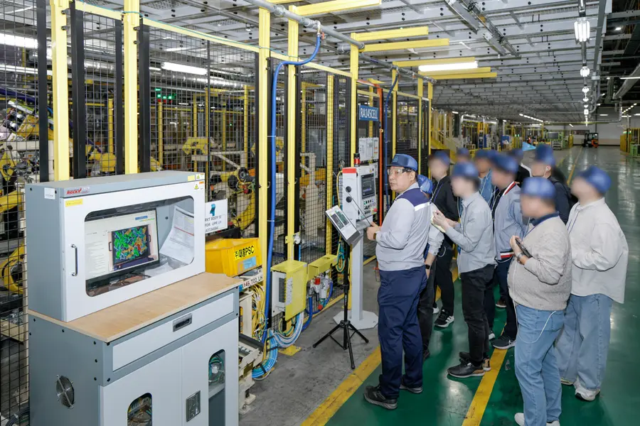 GM 창원 공장의 빈 피킹 기술 설명을 듣고 있는 취재진. GM 제공