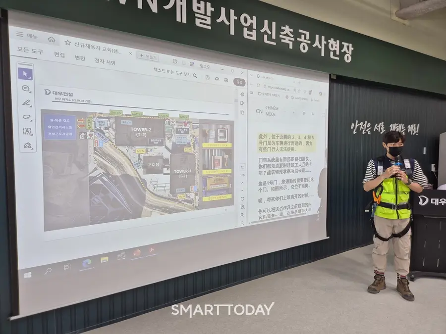대우건설 관계자가 과천 G-TOWN 개발사업 신축공사 현장에서 외국인 근로자를 위한 AI 번역기 기능에 대해 설명하고 있다. (사진=대우건설)