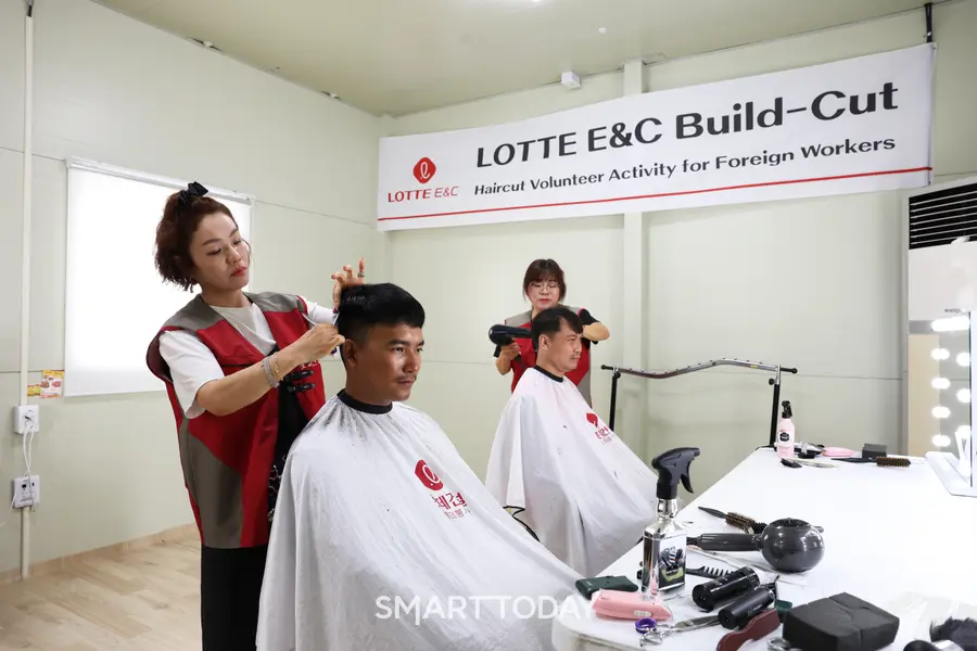 세종시 ‘들목교 외곽순환도로’ 건설현장에서 외국인 근로자들이 이미용 봉사 서비스를 받고 있다. (사진=롯데건설)