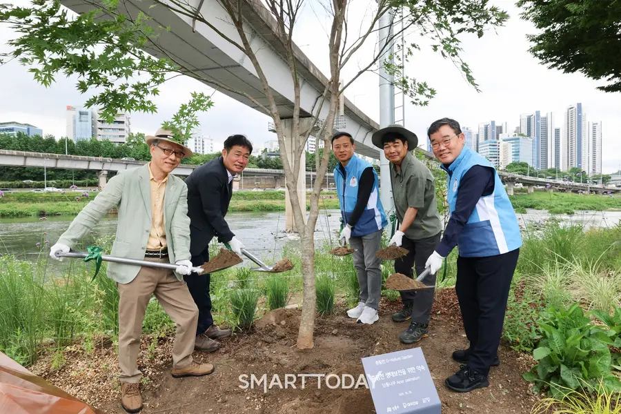 고광현 성동구 부구청장(왼쪽에서 두번째)과 김보현 대우건설 대표이사(오른쪽에서 첫번째)가 중랑천대에서 단풍나무를 식재하고 있다. (사진=대우건설)