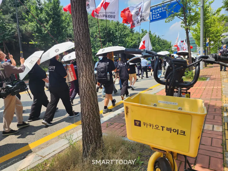 카카오 노조 조합원들이 카카오 T 바이크가 비치된 인도 옆 도로를 걷고 있다. 출처=김종현 기자
