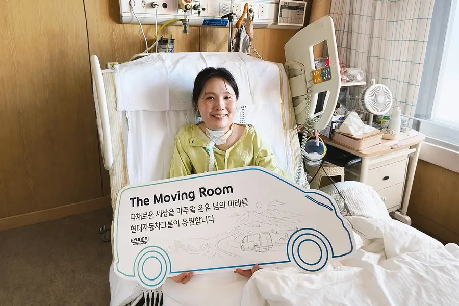 김온유 씨가 병상에서 현대차그룹 The Moving Room 프로젝트 피켓을 들어 보이고 있다. 출처=현대차그룹