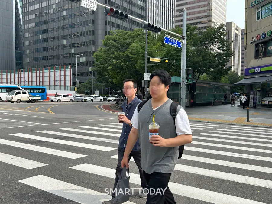 A씨가 도시락 가방과 저가커피를 들고 여의도 횡단보도를 건너는 모습. 최아랑 기자