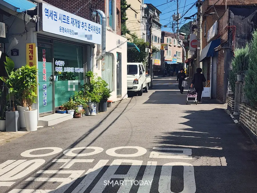 시민들이 숙대입구역세권 재개발 추진준비위원회 사무실 앞 길을 지나가고 있다. 출처=김종현 기자