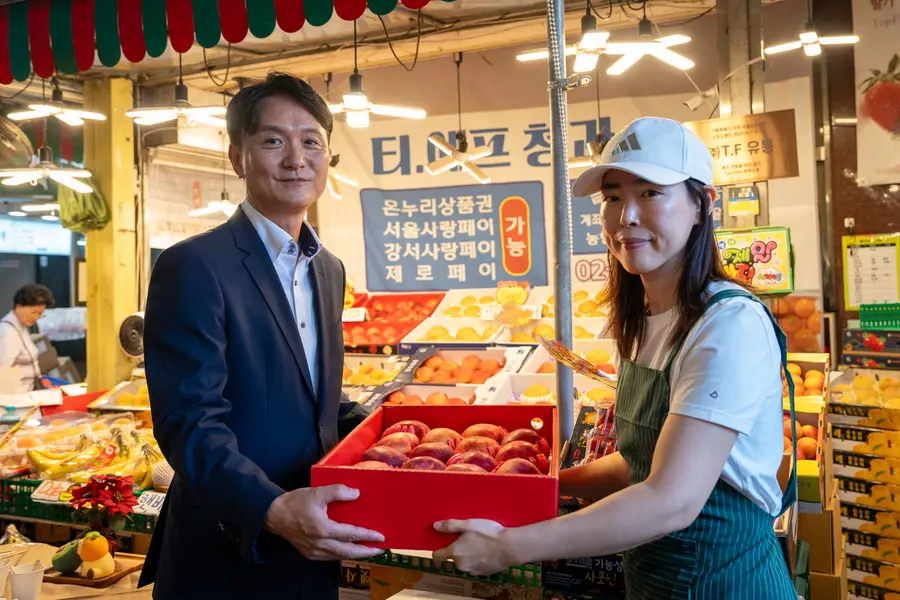 엄주성 키움증권 대표(왼쪽)가 지난 18일 오전 금융권 추석 나눔 행사에 참여, 서울 강서구 방신전통시장에서 사과를 구매하고 있다. 구매한 물품은 지역사회 취약계층과 사회복지단체에 전달했다. 사진 키움증권