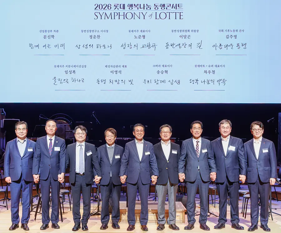 문신학 산업통상부 차관, 노준형 롯데지주 대표이사, 이달곤 동반성장위원회 위원장 등 참석자들이 지난 3월 서울 롯데콘서트홀에서 열린 '2026 롯데 행복나눔 동행콘서트'에서 손을 맞잡고 기념촬영을 하고 있다. 롯데 제공