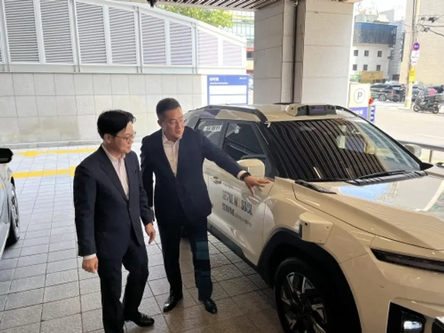본격적인 강남 도심 로보택시 시승을 앞두고 산업통상부 김정관 장관(왼쪽)에게 SWM의 로보택시 기술을 설명하는 김기혁 대표(오른쪽)(사진 제공: SWM(에스더블유엠))