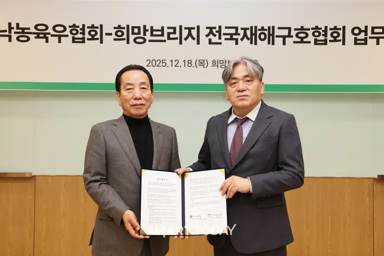 희망브리지 임채청 회장(오른쪽)이 한국낙농육우협회 이승호 회장과 재난취약계층 지원 업무협약을 체결한 뒤 기념사진 촬영을 하고 있다.(사진=희망브리지)